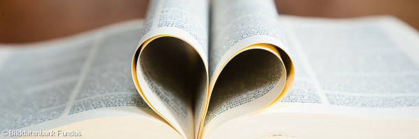 Aufgeschlagene Bibel - Seiten zum Herz gefaltet